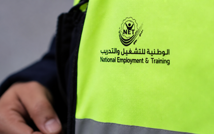 شخص يرتدي سترة عليها شعار الوطنية للتشغيل والتدريب