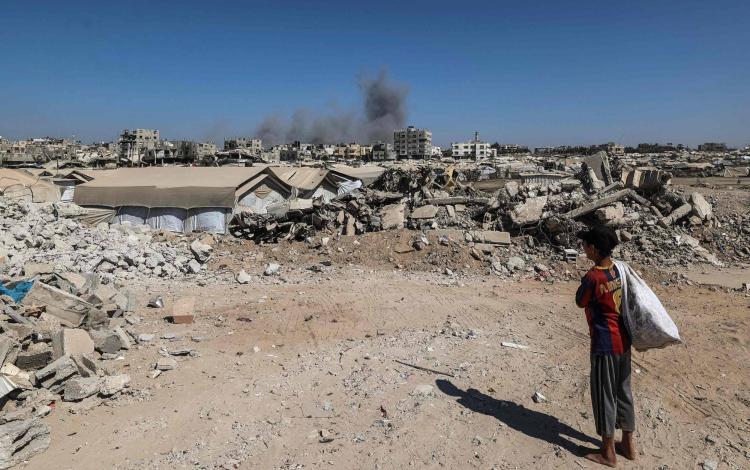 طفل فلسطيني يراقب تصاعد الدخان بعد استهداف منزل بغارة إسرائيلية في مخيم البريج للاجئين وسط غزة 8/9/2026 | وكالة الأنباء الفرنسية